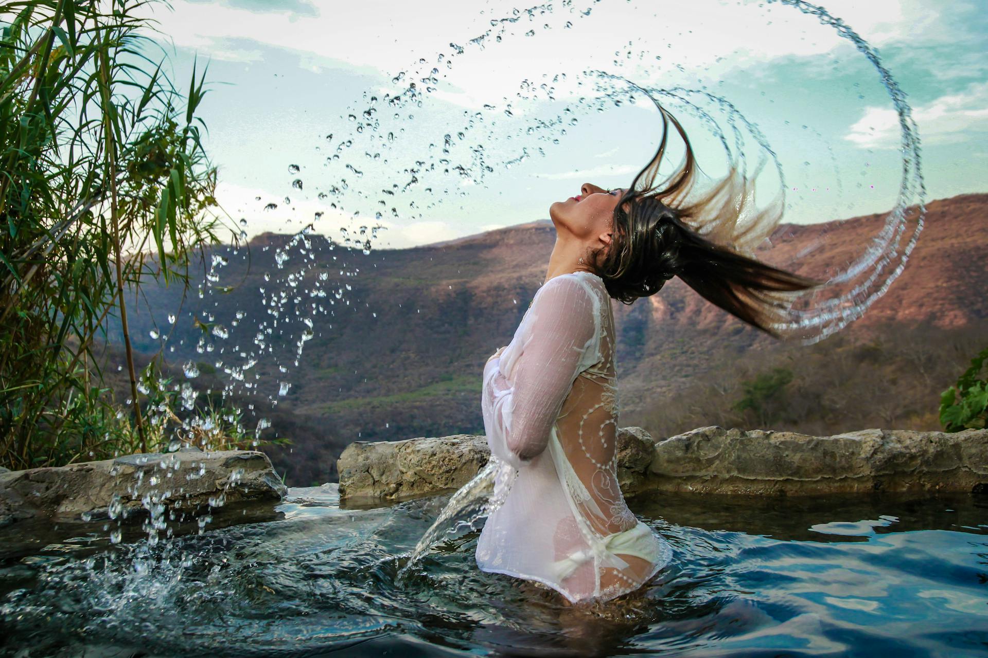 a woman in a white dress in water